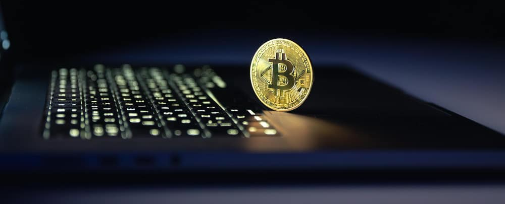 A black image with bitcoin on a laptop keyboard