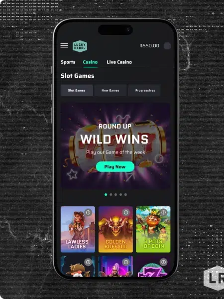 Smartphone showing the Lucky Rebel online casino app with slot games and a 'Wild Wins' game of the week banner.