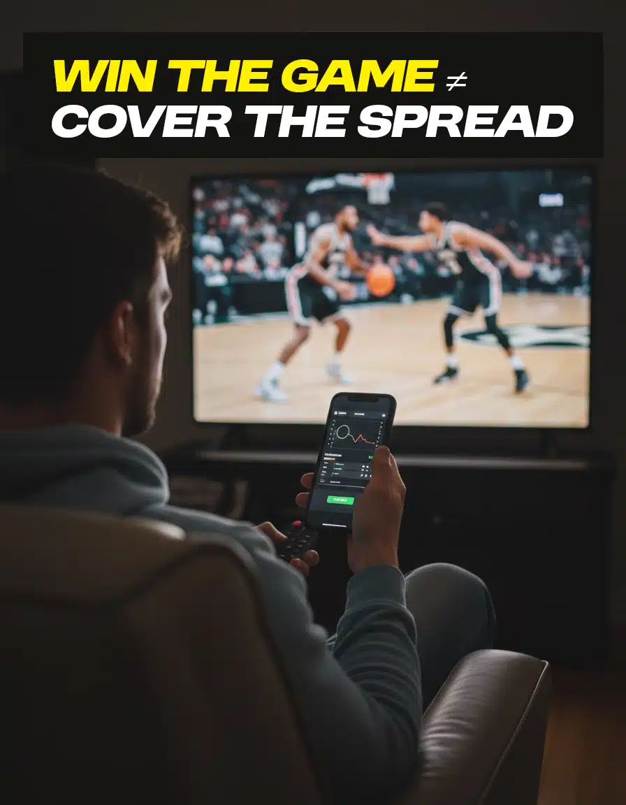 A man is watching a basketball game intently on television, holding a phone with a betting app.