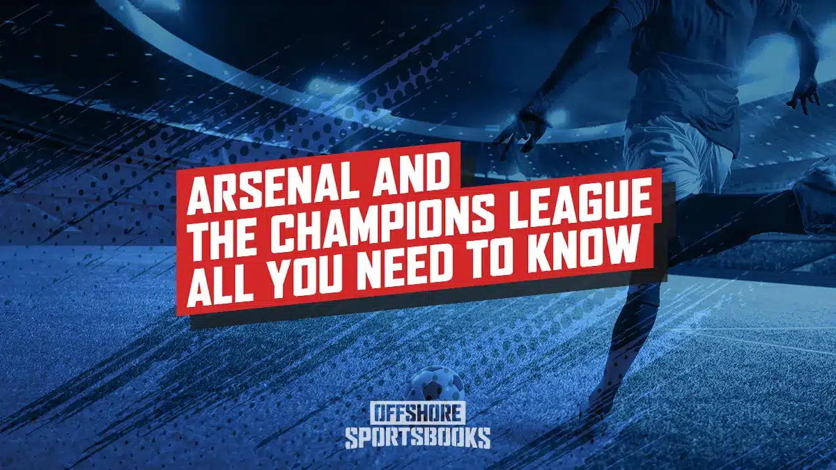 Image of Arsenal player kicking a soccer ball inside a stadium.